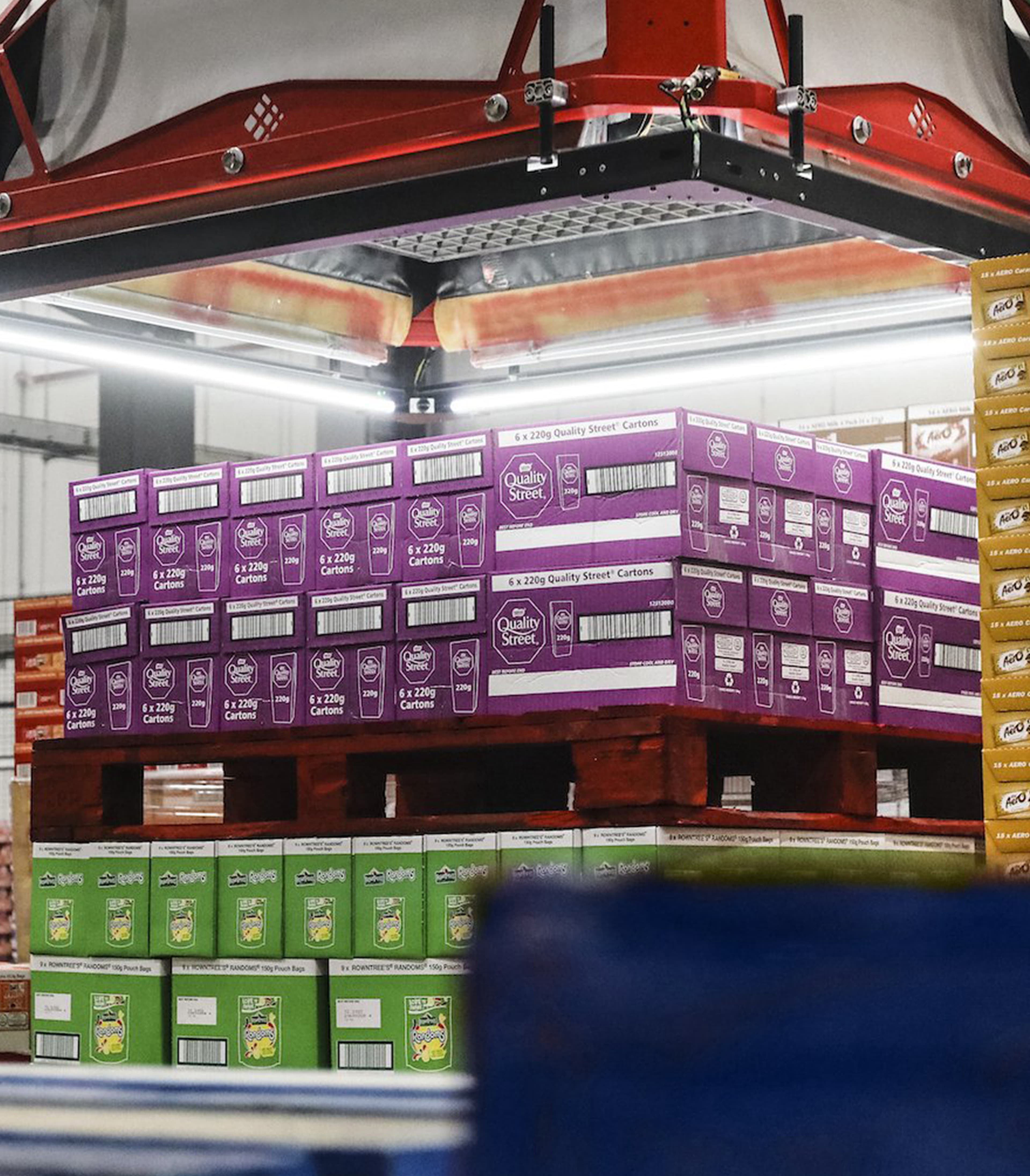Körber automation system moves pallets with packed Quality Street cartons in a warehouse.