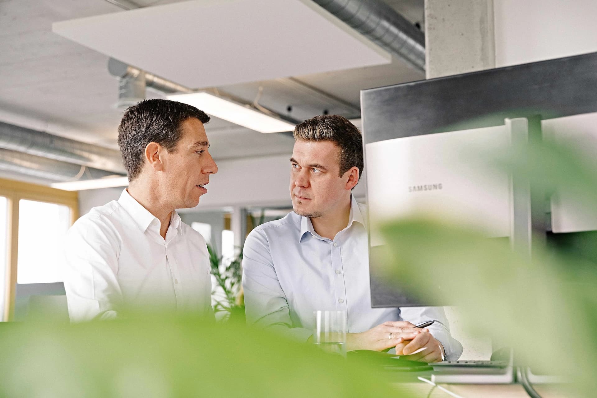 Two Körber employees talking to each other.