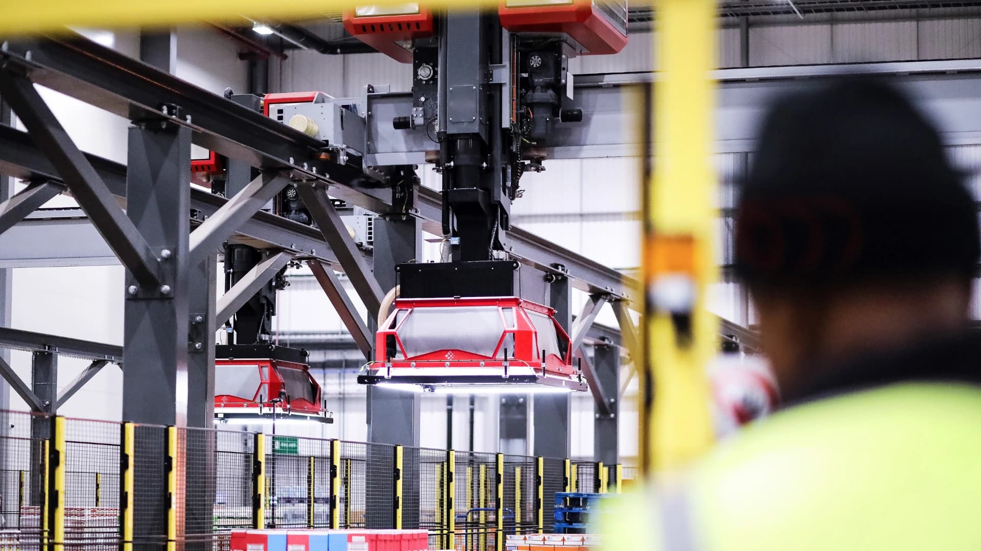 Picture of an employee facing towards an autonomous warehouse machine.