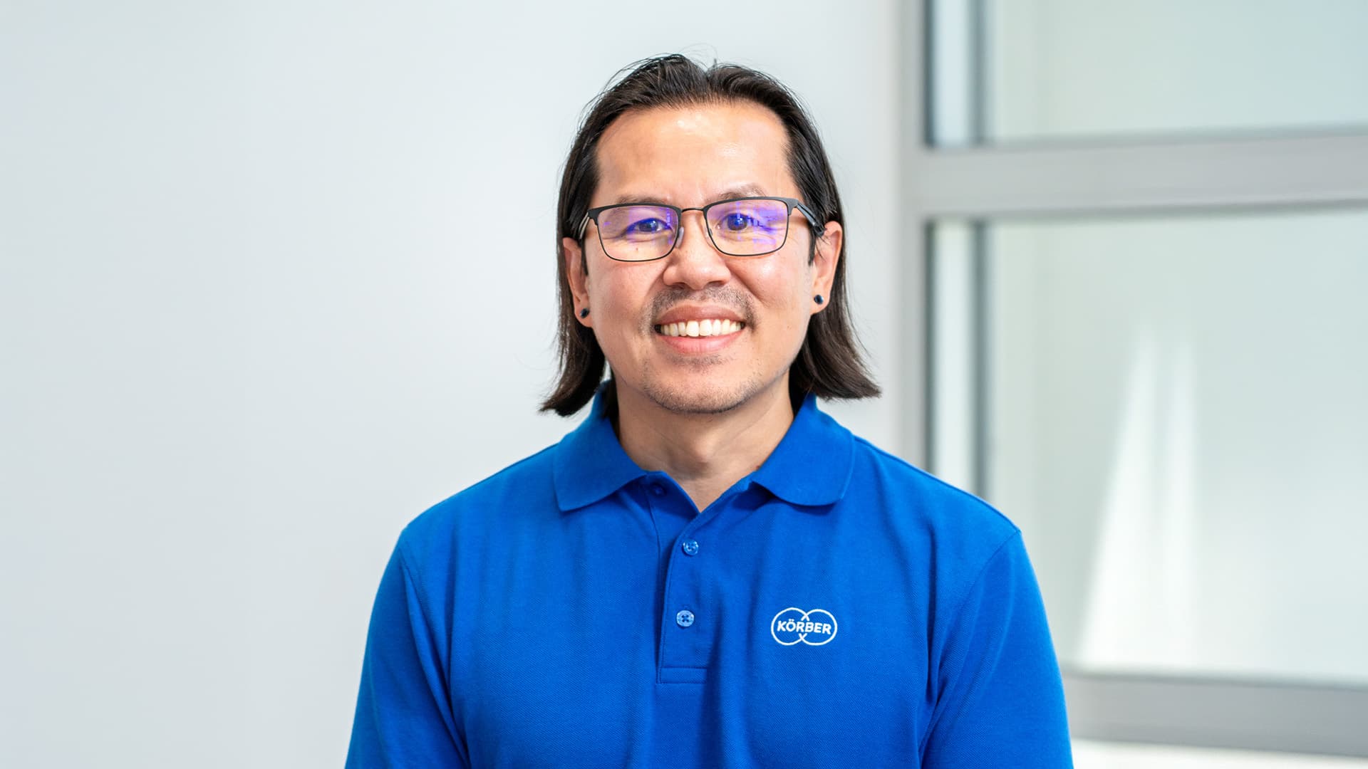 Mann trägt ein blaues T-Shirt der Marke Körber