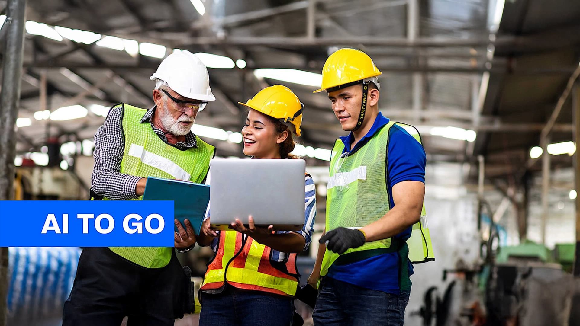 Three warehouse workers analyzing operational data on a computer screen.