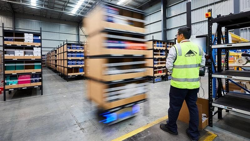 Enge Zusammenarbeit im Warenlager – Mitarbeiter und AMR in einer von Körber entworfenen Automatisierungslösung