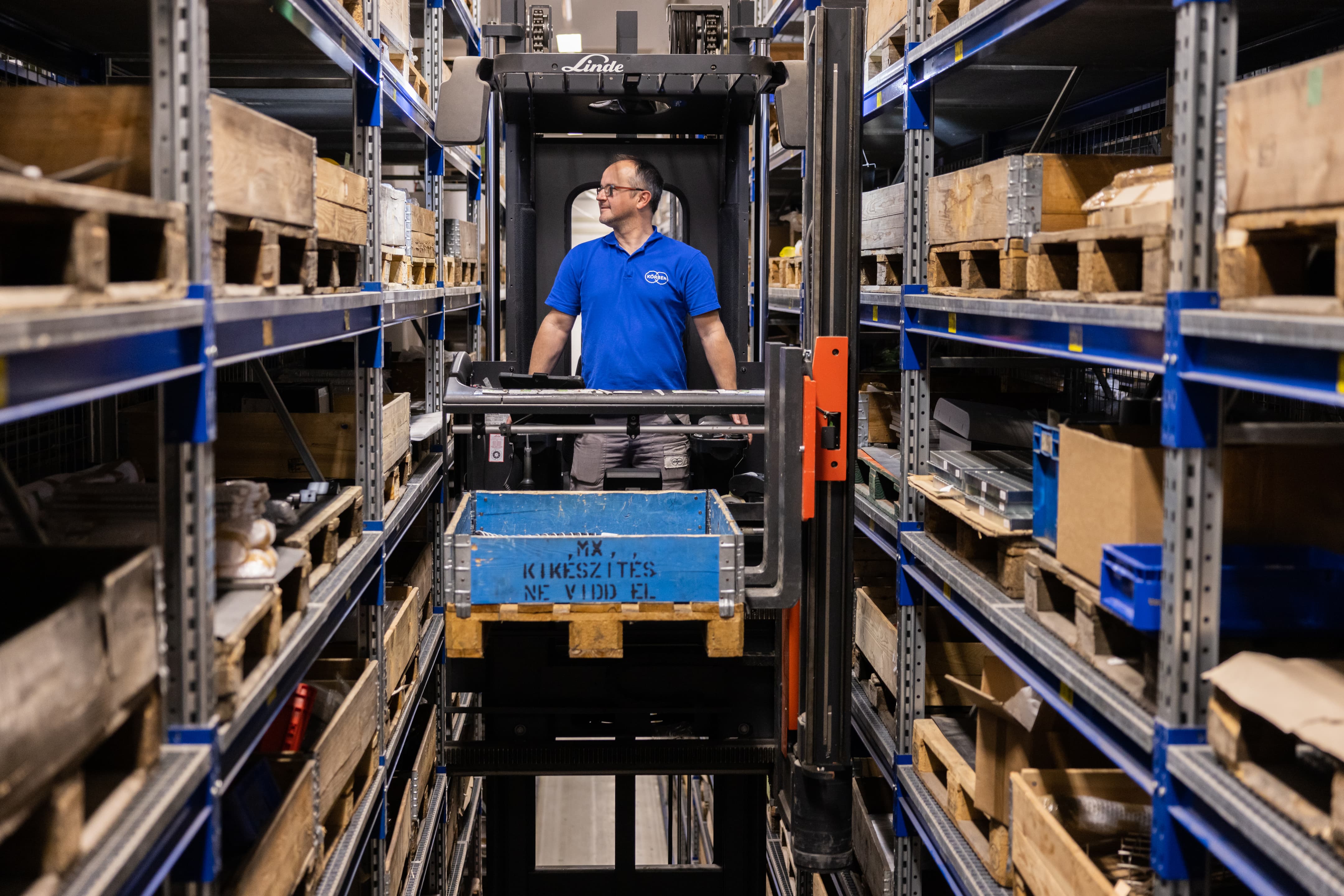 A warehouse scene featuring a man on a forklift