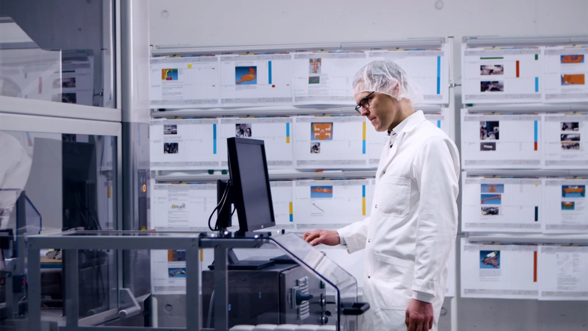 Ein Mann in einem Laborkittel arbeitet an einem Computer in einer Laborumgebung