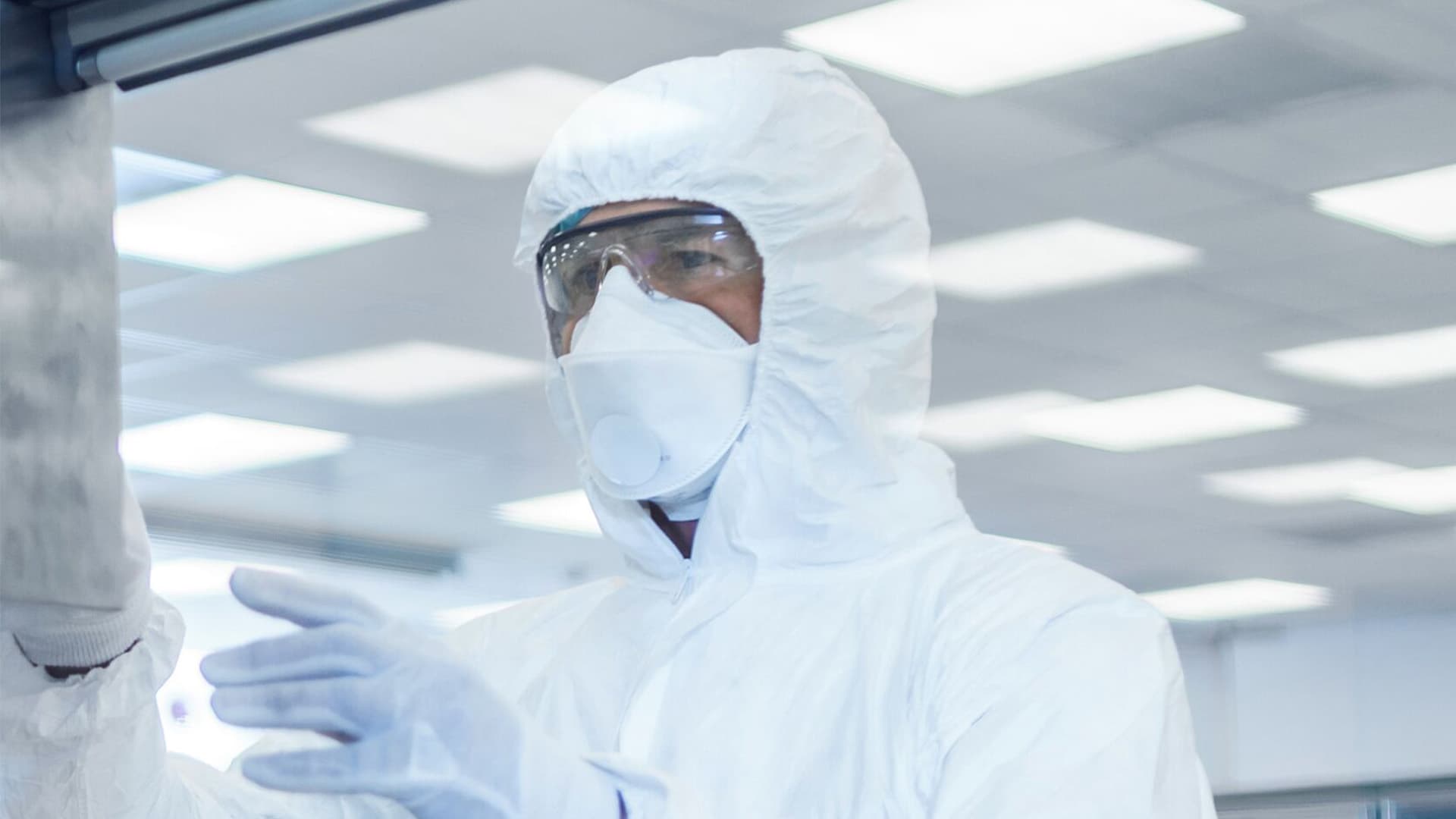 Person wearing personal protective equipment using a touchscreen