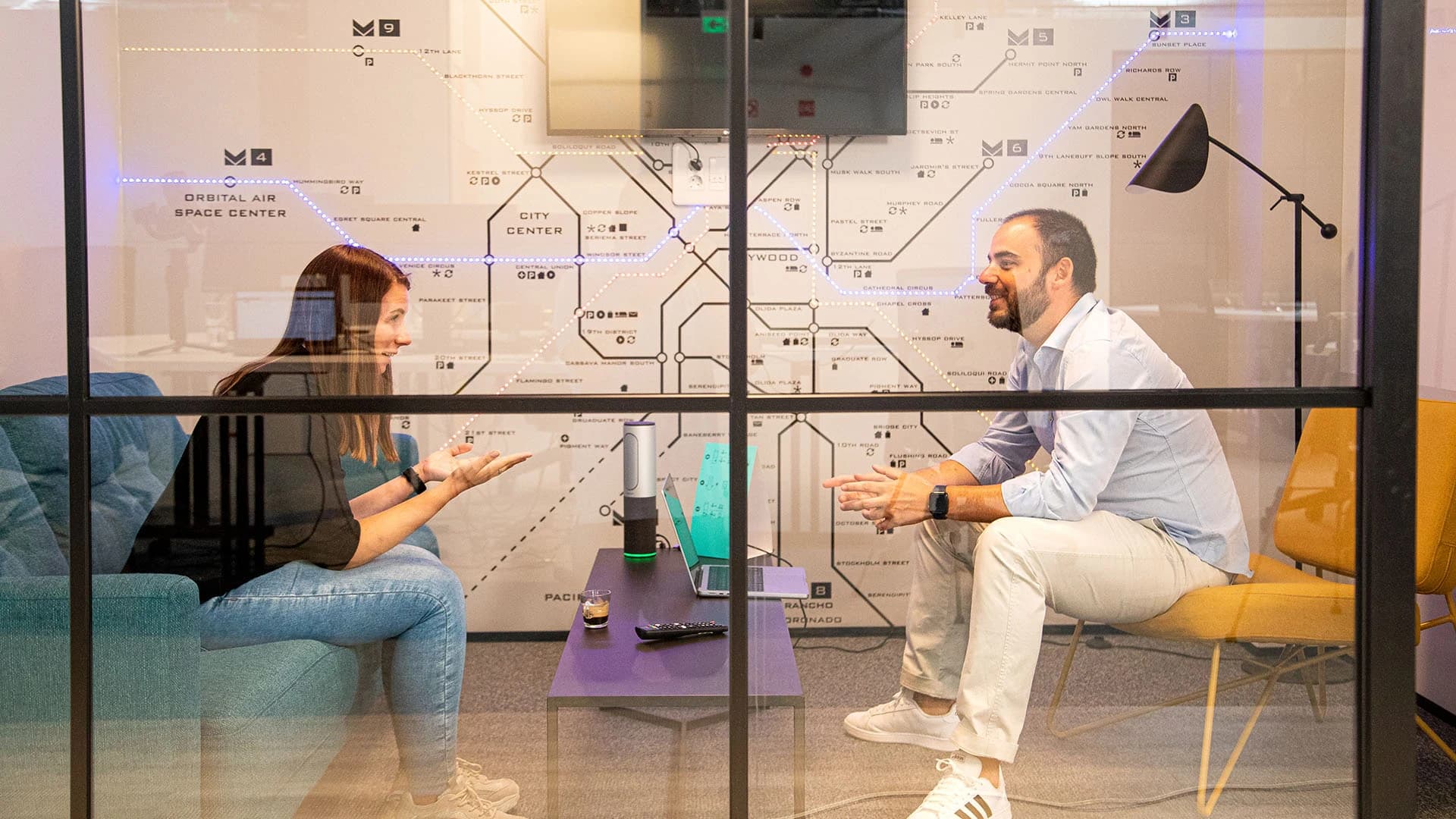 In einem Raum sitzen zwei Personen und unterhalten sich über sichere Cybersicherheitsinfrastrukturen