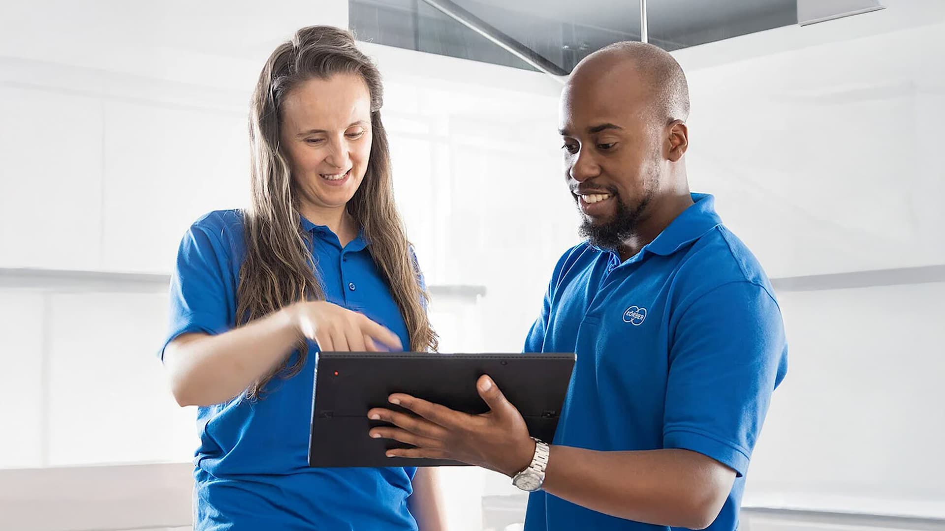 Zwei Körber-Mitarbeiter betrachten ein Tablet-Gerät.