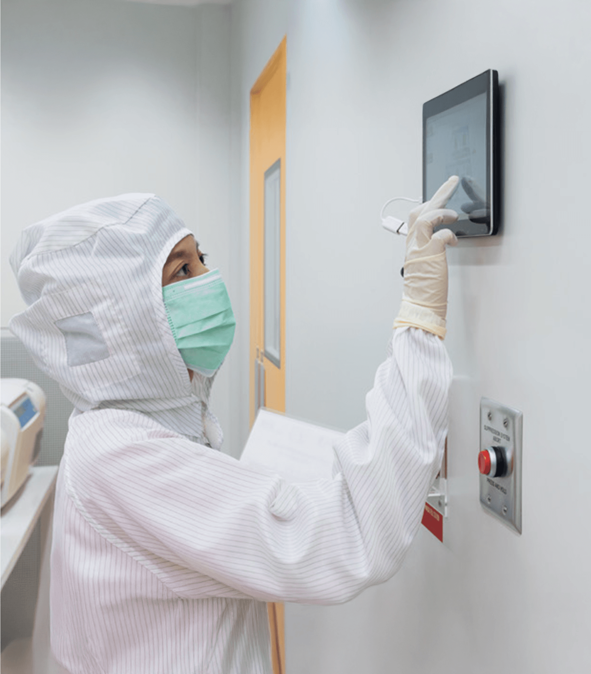 Person wearing personal protective equipment using sofware on a touchscreen