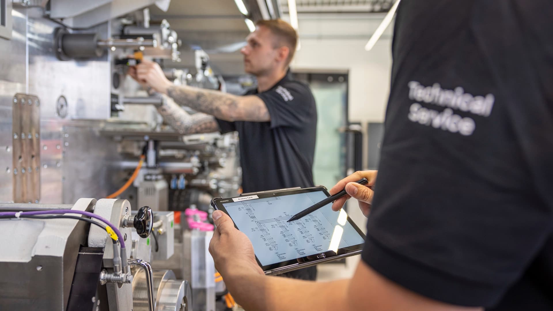 Technical service team working on a industrial machine.