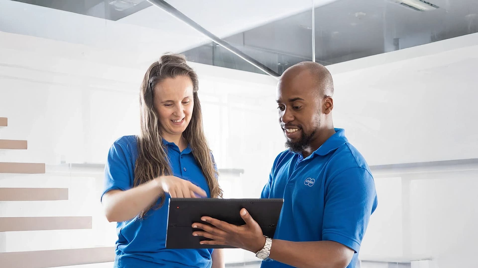 Two Körber employees looking at a tablet device