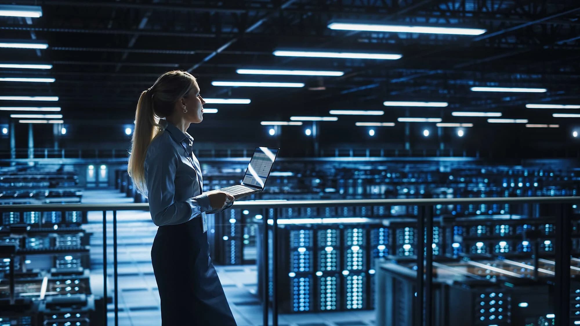 Eine Ingenieurin mit einem Computer in der Hand, die sich mit Fragen der Informationssicherheit beschäftigt.