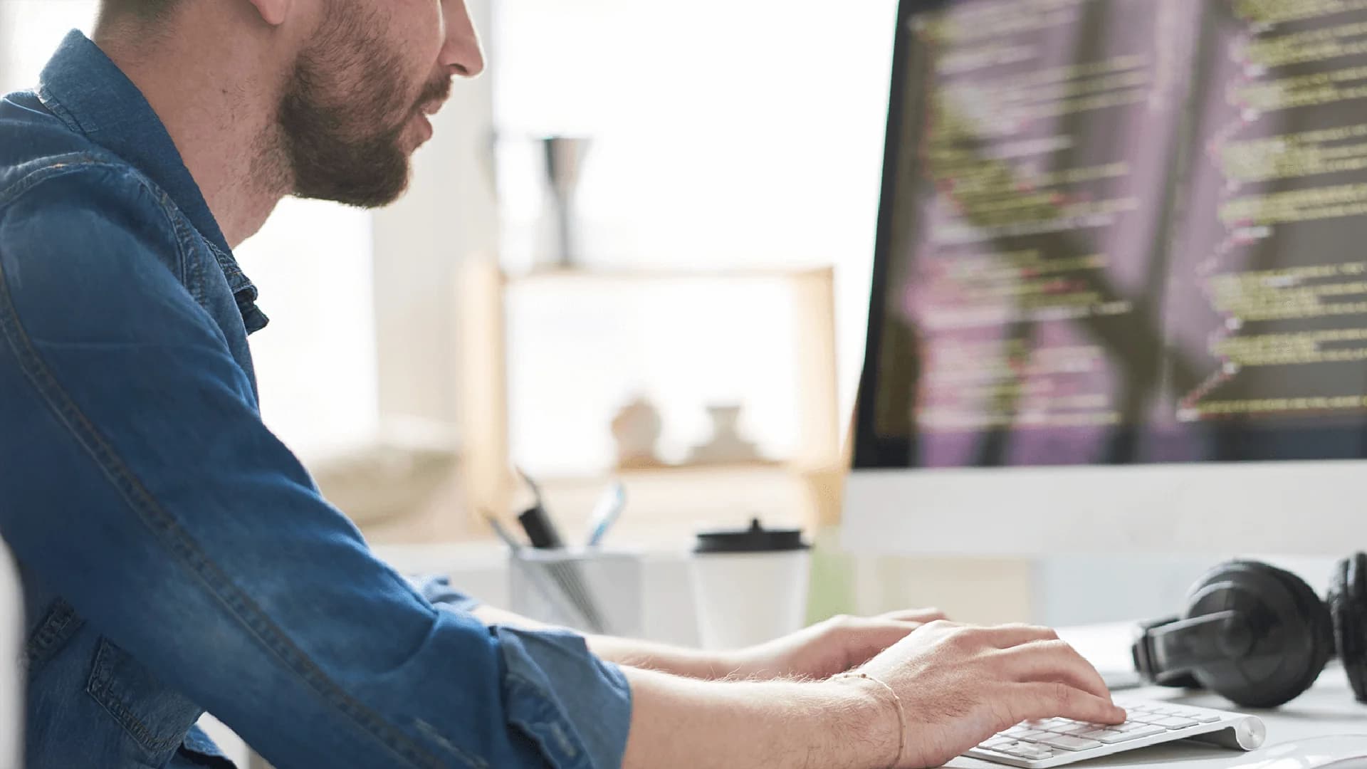 Ein Mann an einem Schreibtisch schaut auf einen Computerbildschirm, auf dem Cybersicherheitszertifikate angezeigt werden.