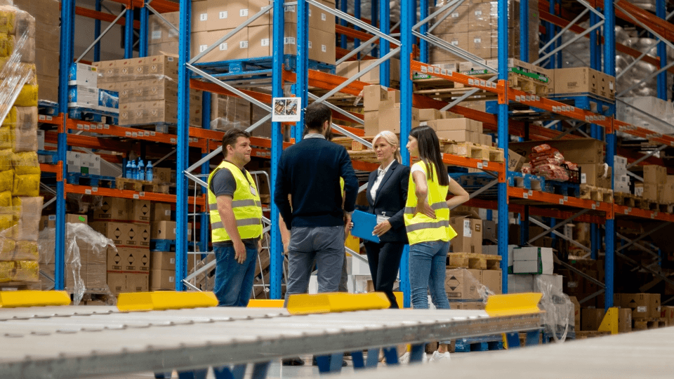 people on a warehouse environment surrounded by shelves and boxes